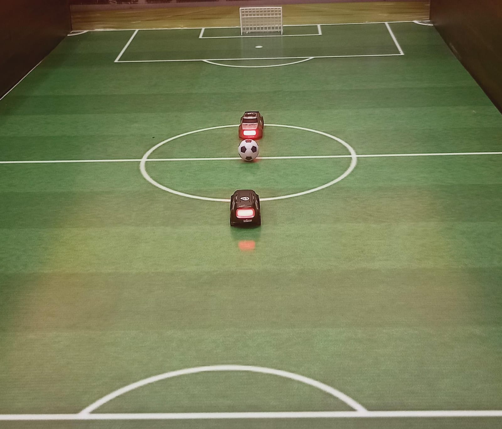 RC cars playing football on a small field