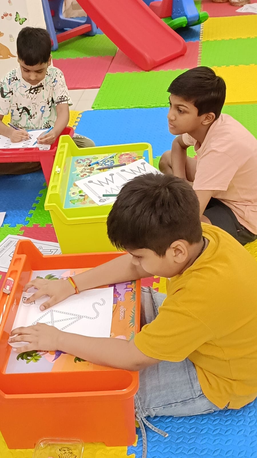 Children enjoying drawing and learning activities in the GAMES BOND playzone